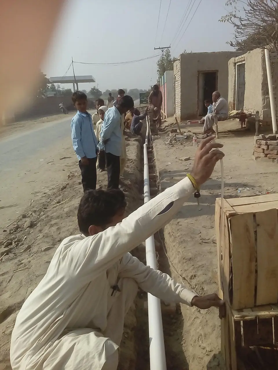 رہائشی ٹیم کے ساتھ سیوریج لائن کی پیمائش کرتے ہوئے۔