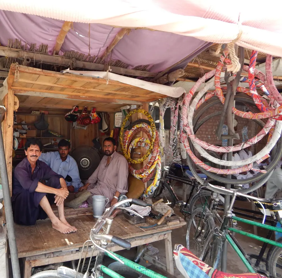 سائیکل مرمت ورکشاپ میں کام کرتے افراد